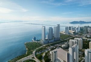 Aerial view of The Lighthauz Residences Penang overlooking the coastal skyline, Penang Bridge and surrounding waterfront developments, emphasizing the prime seafront setting and lifestyle appeal of this penang seafront condo.