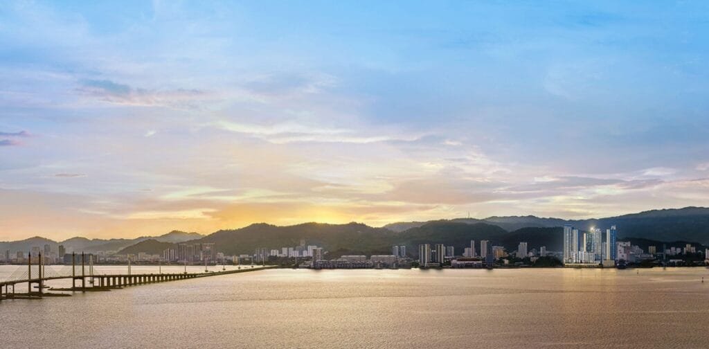 Panoramic aerial masterplan view of The Lighthauz Residences Penang overlooking Penang Bridge, coastal skyline and surrounding developments, highlighting prime waterfront positioning of this penang seafront condo by EXSIM.