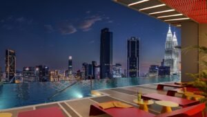 Night view of the infinity pool at Phoeniz Suites @ KLCC with Kuala Lumpur skyline and KLCC landmark in the background.