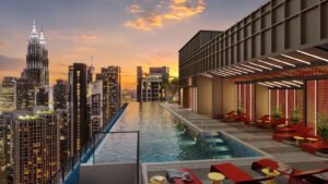 Rooftop pool deck at Phoeniz Suites @ KLCC with sunset skyline view, lounge seating and KLCC city surroundings.