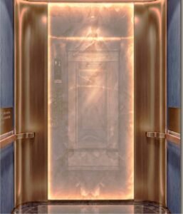 Lift cabin interior at MABA Suitez featuring a backlit marble-effect wall, metallic panels, warm lighting and handrails.