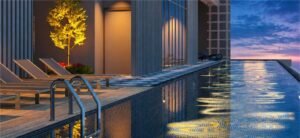 Luxe Pool at MABA Suitez featuring blue mosaic tiles, sun loungers, timber decking and sunset light reflected across the water.